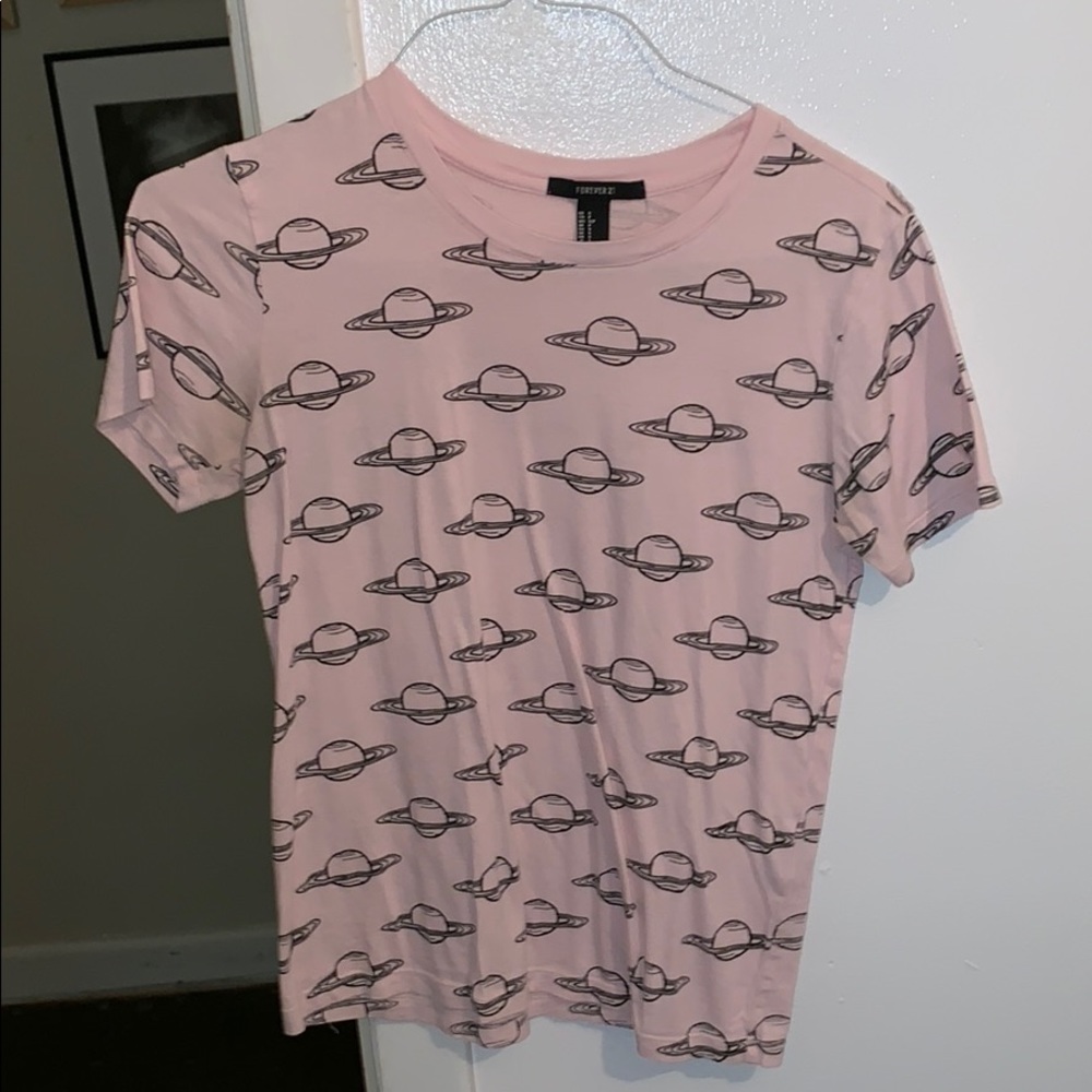 Pink tee with saturns on it.